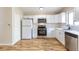 Bright kitchen with white cabinets, stainless steel appliances, and wood-look flooring, creating a modern feel at 11524 Marshall Ct, Broomfield, CO 80020