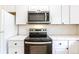 Modern kitchen featuring stainless steel appliances, white cabinets, white subway tile backsplash, and quartz countertops at 11524 Marshall Ct, Broomfield, CO 80020