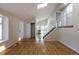 Open living room with hardwood floors, a large window, staircase, and access to the kitchen at 11524 Marshall Ct, Broomfield, CO 80020