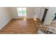 Open living room featuring hardwood floors, a large window, and access to the stairs and front door at 11524 Marshall Ct, Broomfield, CO 80020