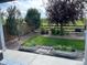 Charming back yard with metal garden planters, mature trees, and lush green lawn at 11023 Pastel Pt, Parker, CO 80134