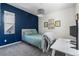 Cozy bedroom featuring a blue accent wall, plush carpet, and a comfortable bed with light-green bedding at 11023 Pastel Pt, Parker, CO 80134