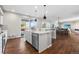 Modern kitchen with a marble island and stainless appliances flows into the dining and living areas at 11023 Pastel Pt, Parker, CO 80134