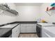 Functional laundry room with sink, storage cabinets, and modern washer and dryer at 11023 Pastel Pt, Parker, CO 80134