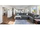 Open-concept living room featuring hardwood floors, a large sectional sofa, and plenty of natural light at 11023 Pastel Pt, Parker, CO 80134