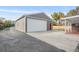 Detached two car garage with white doors, gray siding, and a red entry door at 1945 Yarrow St, Lakewood, CO 80214