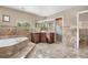 This beautiful bathroom has stone tile, a large soaker tub, and a glass shower at 1945 Yarrow St, Lakewood, CO 80214