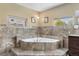 This bathroom has a corner soaker tub with tile surround and natural light at 1945 Yarrow St, Lakewood, CO 80214