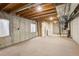 Unfinished basement with carpet, concrete walls, utility connections and a small window at 4720 S Bannock St, Englewood, CO 80110
