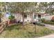 Charming exterior view of a home with green lawn, complemented by mature trees at 4720 S Bannock St, Englewood, CO 80110