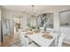 Dining room with white table, chairs, chandelier, and view to the staircase at 591 Rio Rancho Way, Brighton, CO 80601