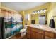 Bathroom with a single sink vanity, light fixture, mirror, and a bathtub with a shower curtain at 10818 Cimarron St # 206, Firestone, CO 80504