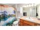 Bathroom with vanity, mirror, and tub with decorative shower curtain at 10818 Cimarron St # 206, Firestone, CO 80504