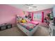Bright bedroom with pink walls, a large window, a ceiling fan, and a closet at 10818 Cimarron St # 206, Firestone, CO 80504