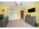Bedroom featuring yellow walls, a closet, a ceiling fan, and a wood dresser at 10818 Cimarron St # 206, Firestone, CO 80504