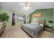 Comfortable bedroom featuring green accent wall, a ceiling fan, and natural light at 10818 Cimarron St # 206, Firestone, CO 80504