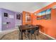 Dining area with orange accent wall and seating for four, adjacent to the kitchen at 10818 Cimarron St # 206, Firestone, CO 80504