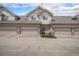 Inviting townhome with neutral siding, stone accents, and attached garages under a blue sky at 10818 Cimarron St # 206, Firestone, CO 80504