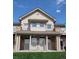 Charming condo building featuring a stone facade and well-manicured lawn under a sunny blue sky at 10818 Cimarron St # 206, Firestone, CO 80504