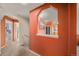 Hallway with orange walls looking into the kitchen, featuring an arched opening at 10818 Cimarron St # 206, Firestone, CO 80504