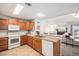 Bright kitchen with wood cabinets, a double sink, and partial view of the living room at 10818 Cimarron St # 206, Firestone, CO 80504