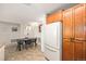 Kitchen with wood cabinets and tile floor is adjacent to dining area with dining table at 10818 Cimarron St # 206, Firestone, CO 80504
