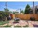A cozy backyard with a stone patio, dining set, lush greenery, and a privacy fence create a relaxing outdoor space at 3622 Lowell Blvd, Denver, CO 80211
