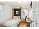 Serene bedroom with a Murphy bed, hardwood floors, and a window overlooking lush greenery at 3622 Lowell Blvd, Denver, CO 80211