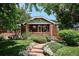 Charming brick home featuring a landscaped front yard with stone pathway and mature trees at 3622 Lowell Blvd, Denver, CO 80211