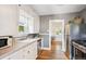 Classic kitchen with stainless steel appliances, white cabinetry, and hardwood flooring at 3622 Lowell Blvd, Denver, CO 80211