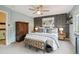 Large main bedroom features patterned wallpaper, a dresser, a ceiling fan, and an end table at 6948 Buckskin Dr, Littleton, CO 80125