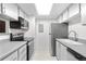 Galley kitchen with stainless steel appliances, white cabinets, and modern countertops at 1758 S Pitkin Cir # A, Aurora, CO 80017