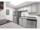 Bright kitchen with stainless steel appliances, white cabinets, modern countertops, and skylight at 1758 S Pitkin Cir # A, Aurora, CO 80017