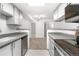 Modern kitchen with stainless steel appliances and gray countertops, flowing into carpeted living space at 1758 S Pitkin Cir # A, Aurora, CO 80017