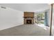 Bright living room featuring a stone fireplace, neutral carpet and an entrance to the outside patio at 1758 S Pitkin Cir # A, Aurora, CO 80017