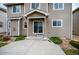 Exterior back patio featuring a concrete pad with a sliding glass door, lush shrubbery, rock features, and beige siding at 1416 Red Mica Way, Monument, CO 80132