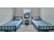 Bright bedroom featuring two twin beds with black metal frames, blue patterned linens, and a central nightstand by the window at 1416 Red Mica Way, Monument, CO 80132