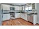 Bright kitchen features stainless appliances, white cabinets, and hardwood floors at 1416 Red Mica Way, Monument, CO 80132