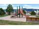 Community playground featuring a slide, climbing structure, bench, and mountain views at 1416 Red Mica Way, Monument, CO 80132