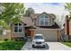 Charming two-story home boasts a well-maintained yard, a driveway with a white car, and beautiful architectural features at 8555 Angela Ln, Parker, CO 80134