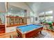 This open-concept living room area is bright with a pool table and wood floors at 8555 Angela Ln, Parker, CO 80134