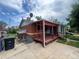 View of brick house featuring a covered front porch, driveway, and trash cans at 882-888 Wolff St, Denver, CO 80204