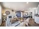 Modern living area with hardwood floors, white couches, and an open kitchen concept at 13586 E 103Rd Pl, Commerce City, CO 80022