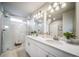 This stunning bathroom features a glass enclosed shower and double vanity with modern fixtures and finishes at 13586 E 103Rd Pl, Commerce City, CO 80022