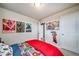 This bedroom features fun wall decor and a cozy red comforter at 13586 E 103Rd Pl, Commerce City, CO 80022