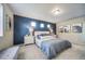 Bedroom features a modern blue accent wall, plush carpet, and ample natural light from three awning windows at 13586 E 103Rd Pl, Commerce City, CO 80022
