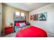 This bedroom features fun wall decor and a cozy red comforter at 13586 E 103Rd Pl, Commerce City, CO 80022