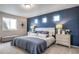 Bright bedroom features a blue accent wall, carpet flooring, and large windows for natural light at 13586 E 103Rd Pl, Commerce City, CO 80022