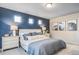 Beautiful bedroom features a blue accent wall, plush carpet, and ample natural light from three awning windows at 13586 E 103Rd Pl, Commerce City, CO 80022