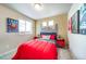 This bedroom features fun wall decor and a cozy red comforter at 13586 E 103Rd Pl, Commerce City, CO 80022